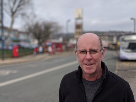 Councillor Martin Love stood in Shipley Market place with the clock tower in the bacground