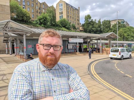 Councillor Matt Edwards stood outside Bradford Forster Square with arms crossed