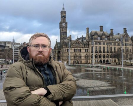 Councillor Matt Edwards stood with his arms crossed in front of Bradford City Hall.