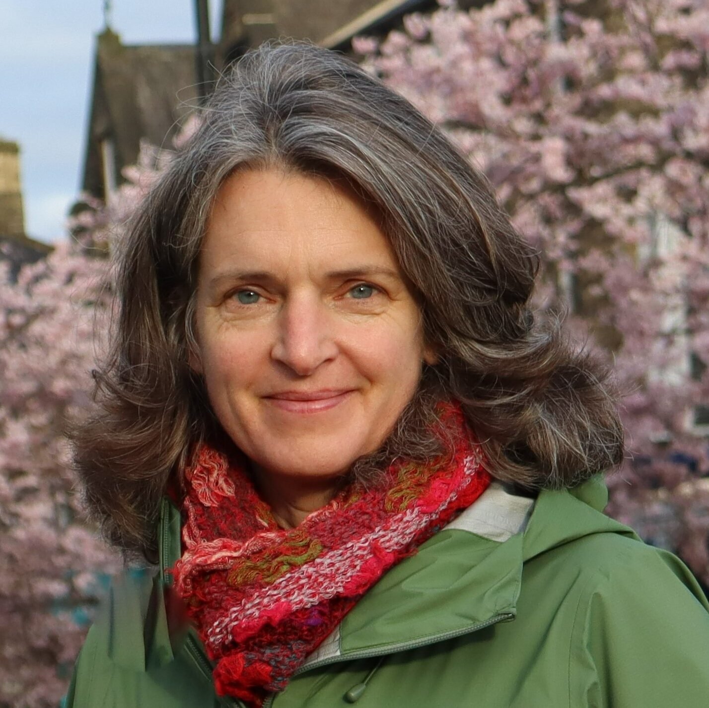 A close up of Ros Brown Standing in front of a blossom tree